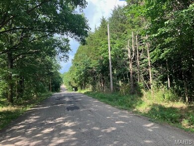 View of asphalt road featuring a view of trees