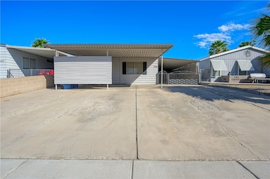 View of front of house with driveway and an attached carport