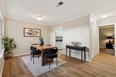Dining space with crown molding and light wood finished floors