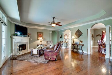 Cozy gas burning fireplace that overlooks the gorgeous saltwater pool! What a view!   Huge room has high tray ceiling and beautiful wood floors. 