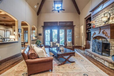 Family room with stone fireplace and beautiful wood beamed ceiling iwth french doors to the covered outdoor patio.