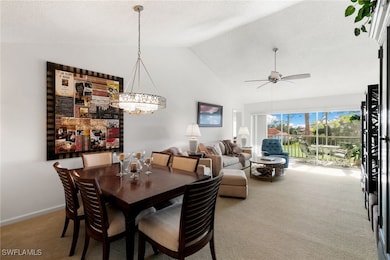 Carpeted dining space featuring a textured ceiling, ceiling fan, a chandelier, and high vaulted ceiling