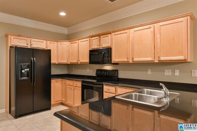 The kitchen offers black granite counters, tile fl