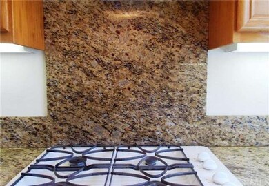GE gas stove with full granite backsplash