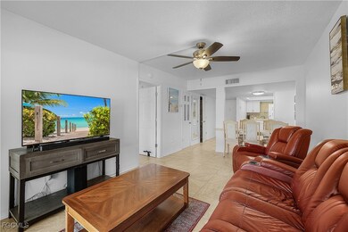 Living room with light tile patterned flooring, a ceiling fan, and a textured ceiling