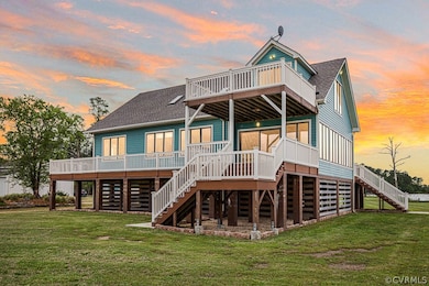 Back house at dusk with a deck and a lawn