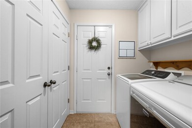 Laundry area featuring a tile floor, cabinet space, and washer and dryer