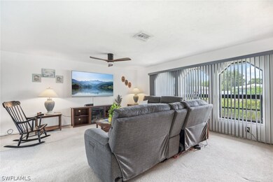 Living room with light carpet and ceiling fan