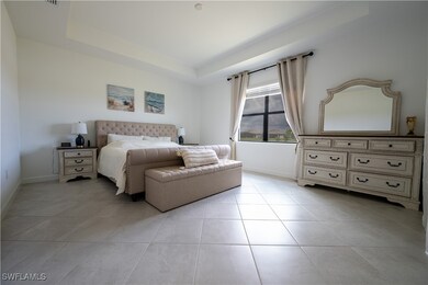 Bedroom featuring a raised ceiling, baseboards, an