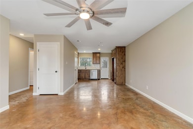 Unfurnished living room with sink and ceiling fan