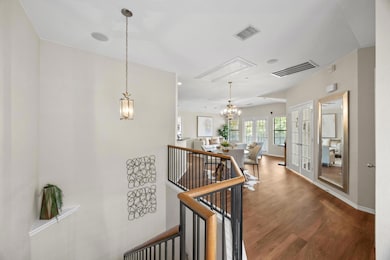 Hall with a chandelier, dark wood-type flooring, 