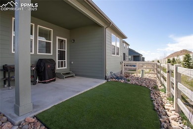 Fully landscaped backyard with artificial turf, rock, and fence.