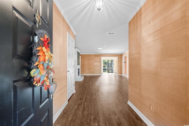 Corridor featuring dark wood-style flooring and ornamental molding