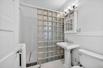 Fully remodeled bathroom with a walk-in block glass shower.
