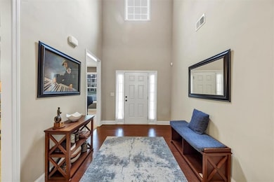 Foyer entrance with visible vents, baseboards, a t