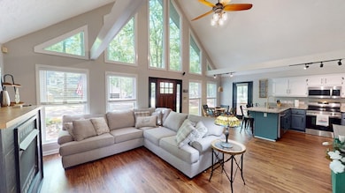 Living area with light wood-style flooring, rail l