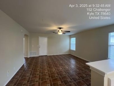 Unfurnished living room featuring arched walkways and ceiling fan