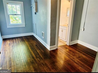 Unfurnished room with dark wood-type flooring and baseboards