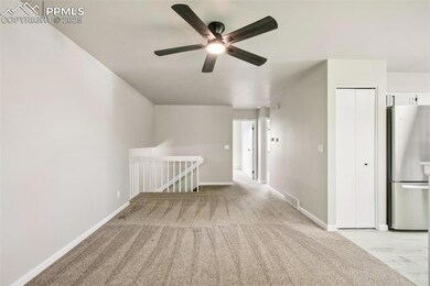 Spare room with ceiling fan, baseboards, and light colored carpet