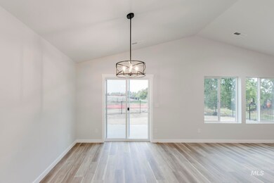 Unfurnished dining area with plenty of natural light, light wood-type flooring, vaulted ceiling, and a chandelier
