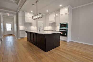 Kitchen with a kitchen island with sink, oven, lig