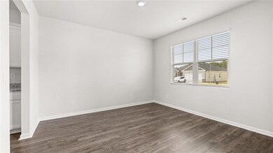 Spare room with dark wood-style floors and baseboards