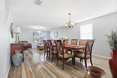 Dining space with light wood-style flooring and a chandelier