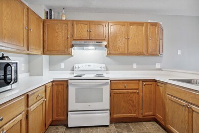 Kitchen features white-on-white appliances and a new stainless steel range hood.