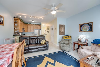 Living room with light tile patterned floors, a ceiling fan, and rail lighting