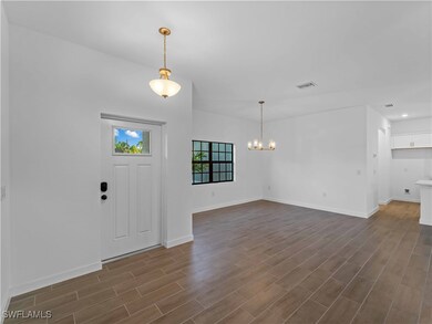 Foyer featuring a chandelier, dark wood-style floo