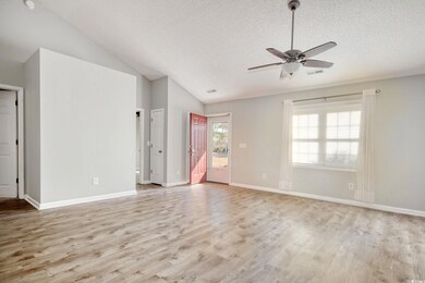 Empty room with lofted ceiling, ceiling fan, a tex