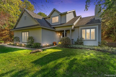 Traditional home featuring a lawn, a shingled roof, and a chimney
