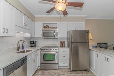 Kitchen with appliances with stainless steel finishes, white cabinetry, ceiling fan, and light hardwood / wood-style flooring