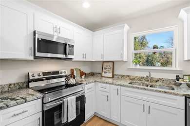 Kitchen featuring light stone countertops, applian