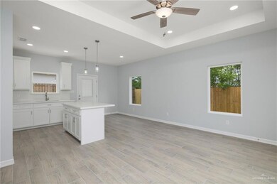 Kitchen featuring white cabinetry, recessed lighting, a kitchen island, hanging light fixtures, and light wood-style flooring