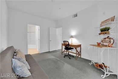 Bedroom with carpet floors, an office area, and en