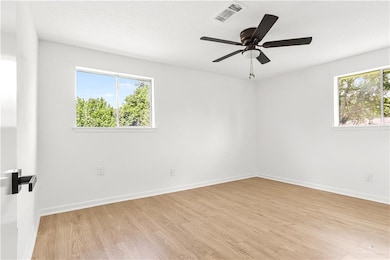 Empty room featuring light wood-style floors and a ceiling fan