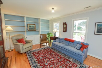 Formal living room with hardwood floors, built in
