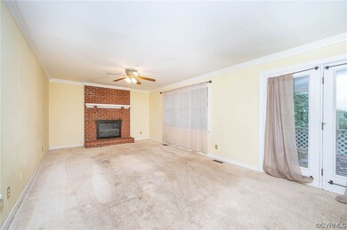 Living room with light colored carpet, a brick fir