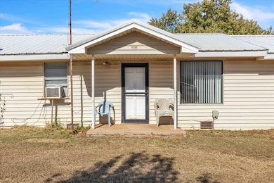 View of front of property featuring a metal roof and a porch