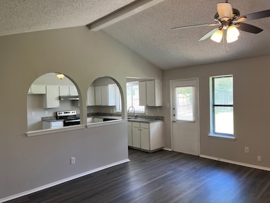 Kitchen featuring white cabinets, dark wood-style floors, electric stove, a textured ceiling, and a ceiling fan