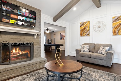 Living room featuring a ceiling fan, dark wood fin