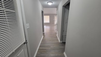 Hallway featuring a textured ceiling and dark wood-type flooring