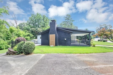 View of side of property featuring a chimney and brick siding