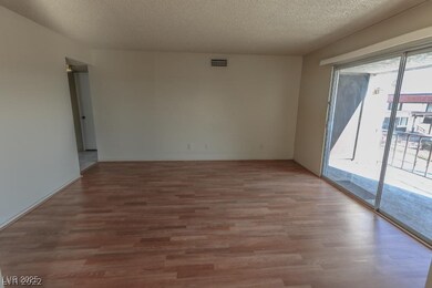 Unfurnished room with wood finished floors and a textured ceiling