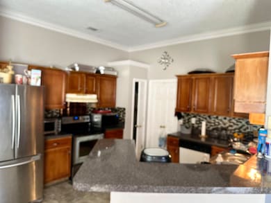 Kitchen with crown molding, appliances with stainl