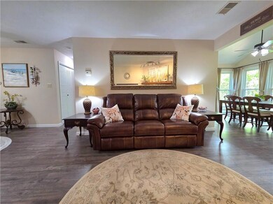 Living room with wood finished floors, visible ven