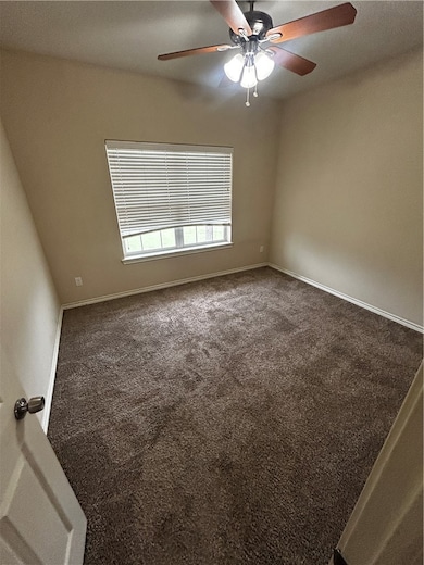 Spare room with a ceiling fan and carpet flooring