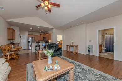 Living room with vaulted ceiling, ceiling fan, and wood-type flooring