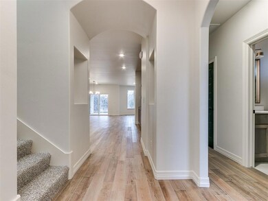 Corridor featuring an inviting chandelier and ligh